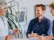 Drei Mitarbeitende von Sutter Medizintechnik im Gespräch während einer Teambesprechung – Fokus auf Austausch und Zusammenarbeit