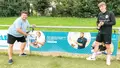Zwei Männer montieren eine Sutter-Werbebande mit Karriereaufruf am Fußballplatz des FC Emmendingen, beide halten einen Akkuschrauber in der Hand und lächeln.