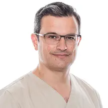 Dr. Kasten mit Brille und Hemd vor hellem Hintergrund.