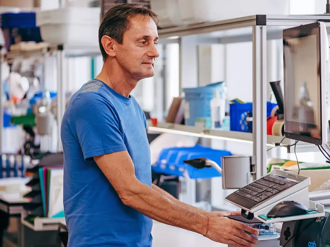 Ein Mitarbeiter von Sutter Medizintechnik bedient eine Fertigungsmaschine in der Produktion – Fokus auf Präzision und Effizienz