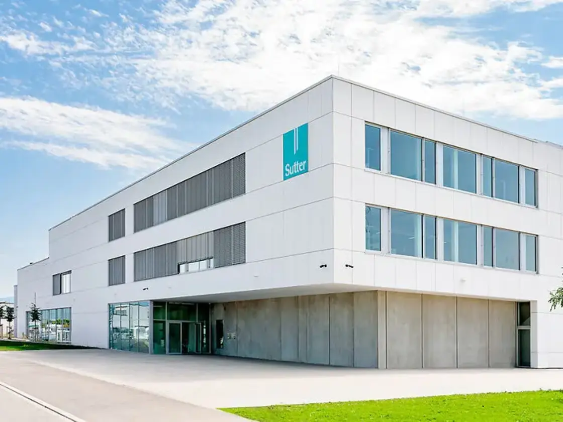 Moderner Unternehmenssitz von Sutter Medizintechnik in Emmendingen mit weißer Fassade, großen Glasflächen und Sutter-Logo.