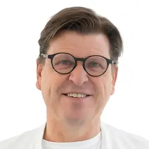 Prof. Dr. Torstein R. Meling mit Brille und in Arztkittel vor weißem Hintergrund.