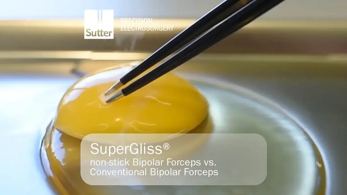 Nahaufnahme eines Eigelbs, das mit SuperGliss® non-stick bipolaren Pinzetten von Sutter Medizintechnik berührt wird, Vergleichstest mit konventionellen Pinzetten.