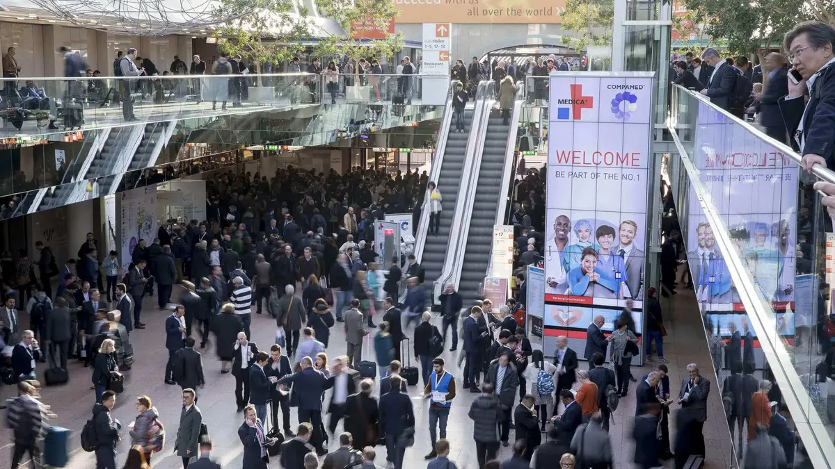 Blick in die Eingangshalle der MEDICA / COMPAMED Messe in Düsseldorf mit zahlreichen Besuchern und Ausstellern – Treffpunkt der internationalen Medizintechnikbranche.