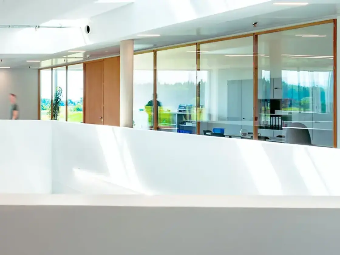 Helle Büroetage mit Glasfronten und Durchgangsbereich bei Sutter Medizintechnik, moderner offener Baustil mit Tageslicht.
