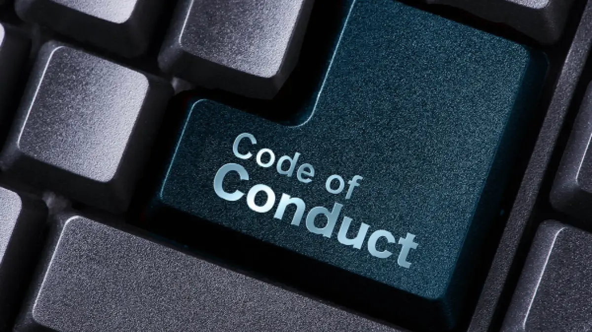 Nahaufnahme einer Computertastatur mit einer hervorgehobenen petrolfarbenen Taste, auf der „Code of Conduct“ steht.