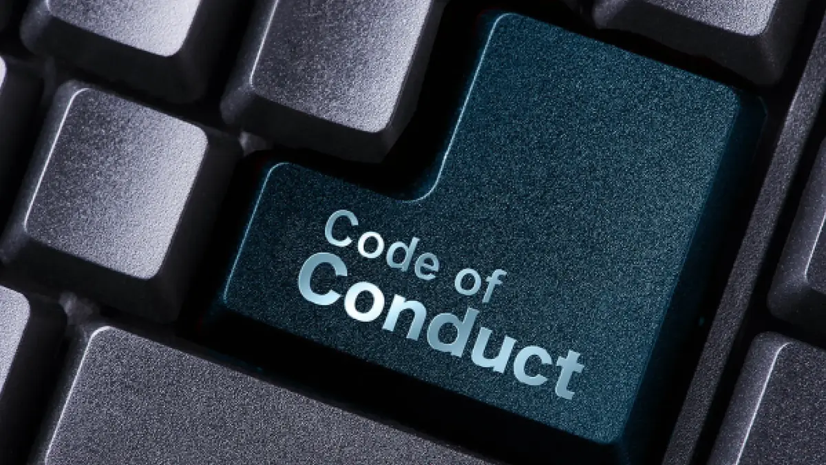 Nahaufnahme einer Computertastatur mit einer hervorgehobenen petrolfarbenen Taste, auf der „Code of Conduct“ steht.