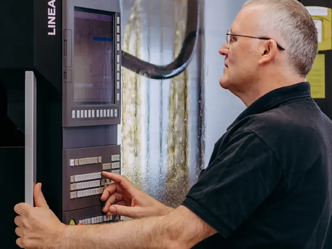 Erfahrener Mitarbeiter von Sutter Medizintechnik bedient eine CNC-Fräsmaschine zur Herstellung chirurgischer Instrumente